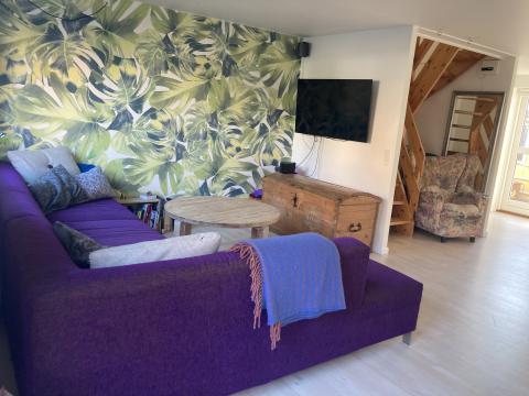 Sofahjørne i stuen, trappen til 1. sal i baggrunden.